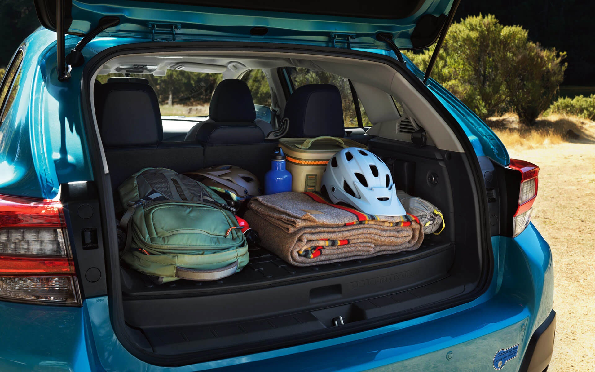 A backpack, blanket, and bike helmet in the rear cargo area of a Crosstrek Hybrid | Subaru Superstore of Chandler in Chandler AZ