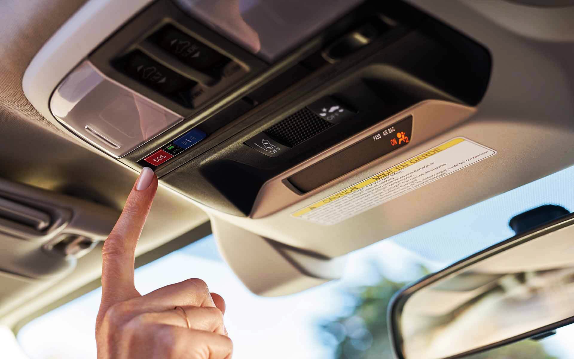 A finger pressing the Crosstrek Hybrid's SOS emergency assistance button | Subaru Superstore of Chandler in Chandler AZ