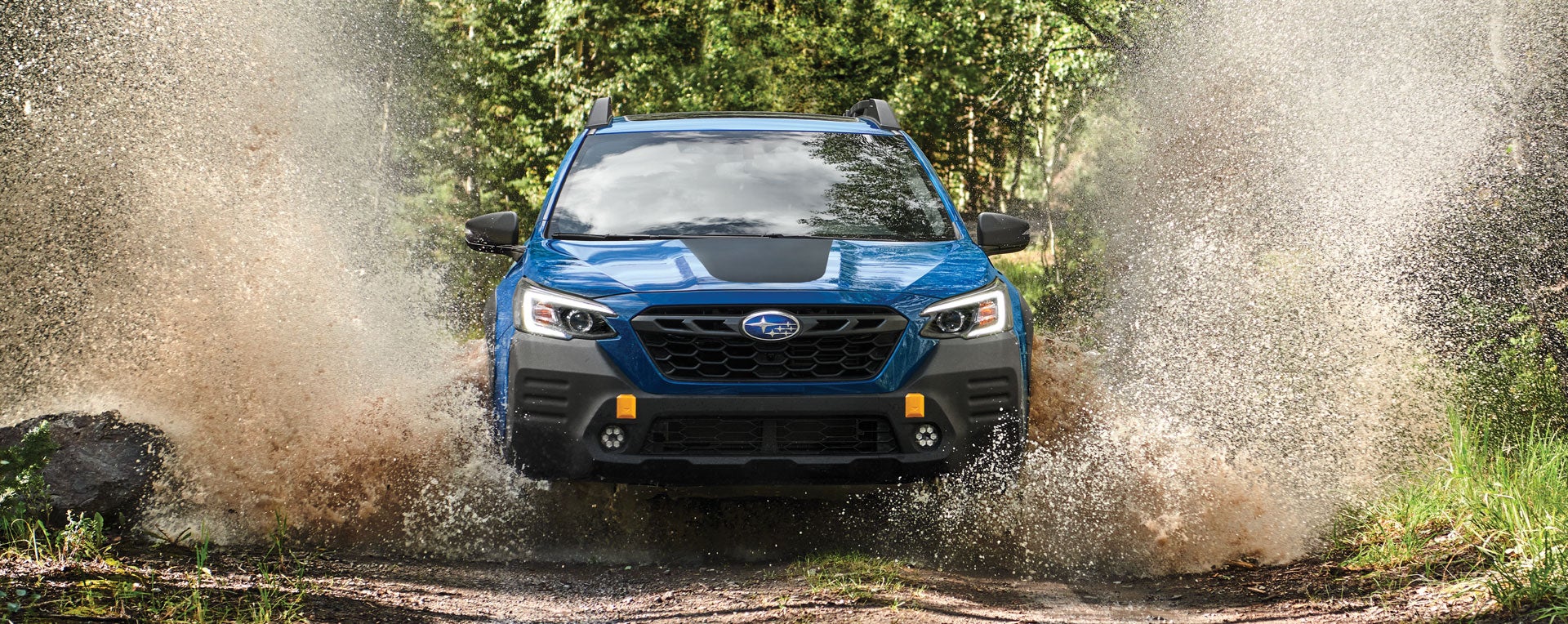 A 2023 Outback Wilderness driving on a muddy trail. | Subaru Superstore of Chandler in Chandler AZ